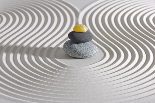 Japanese zen garden with stacked stones and orchid flower