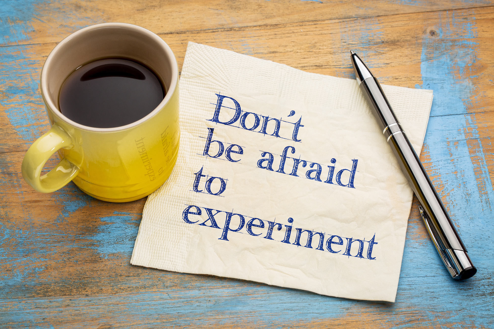 Do not be afraid to experiment - handwriting on a napkin with a cup of espresso coffee